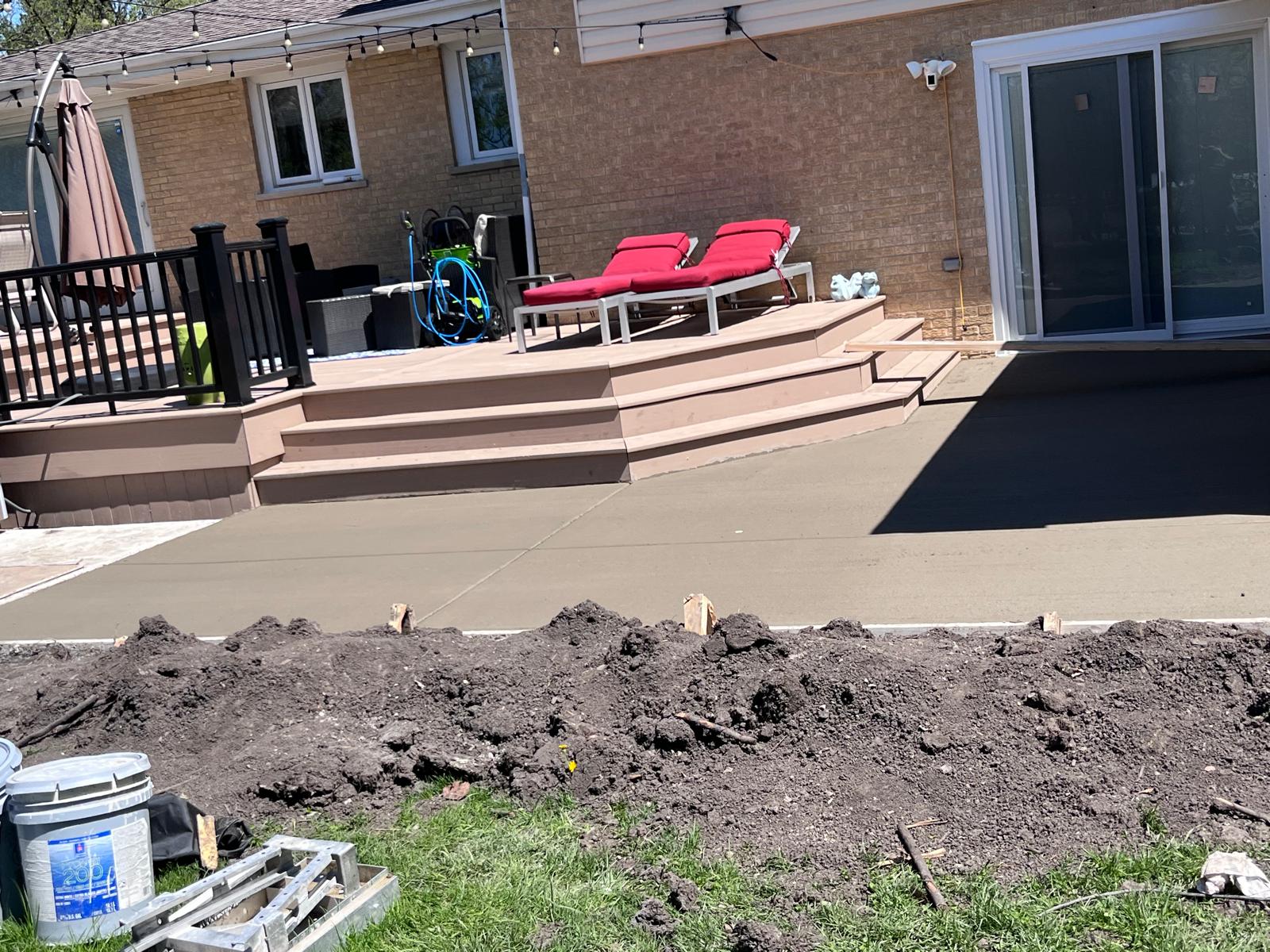 Finished concrete patio by deck